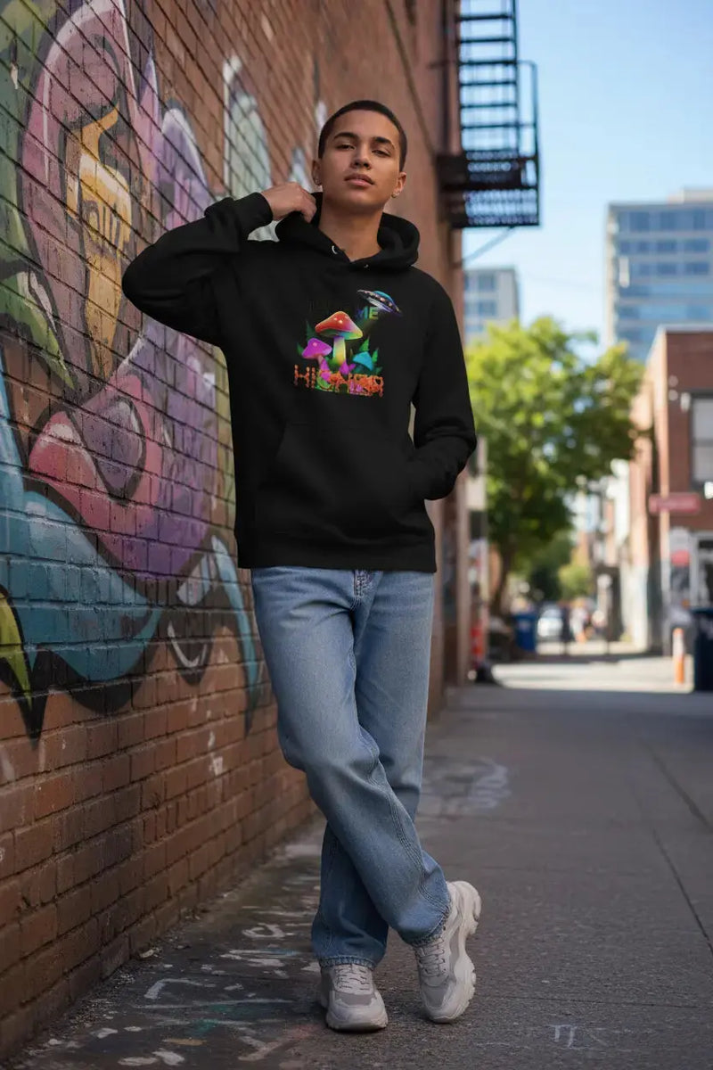 Person wearing TAKE ME HIGHER hoodie in urban setting